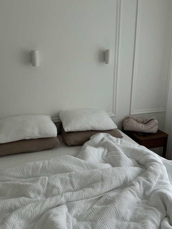 A neatly made bed in a bright, tidy bedroom